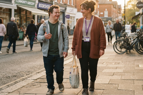 Young adult walking with a support worker through the local community